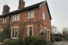 Red brick semi detached house with stone window surrounds and pantile roof