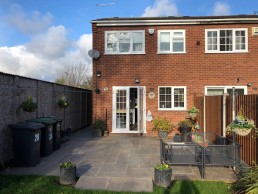 The rear elevation of a two storey house with patio