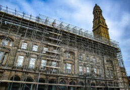 A stone historic building shrouded in scaffolding