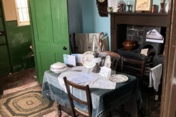 The kitchen of The Breach House with a black and red quarry tile floor and dining table in front of the range