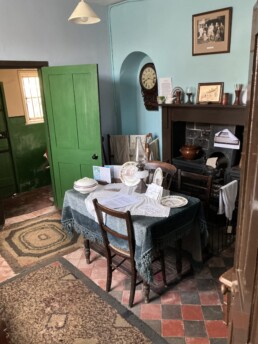The kitchen of The Breach House with a black and red quarry tile floor and dining table in front of the range