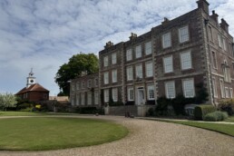 View of the West Elevation of Gunby Hall with the Stable block clock tower in the distance